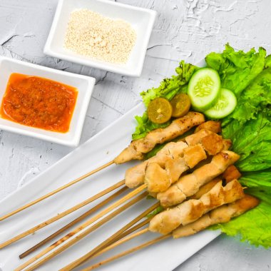 Sate Taichan, kızarmış tavuk, fıstık sosu ve soya sosu olmadan. Tabakta sambal (acı sos) ile servis edilir. Seçili odak.