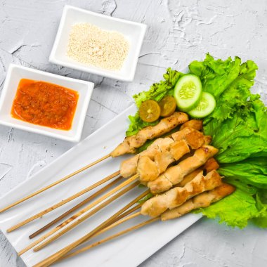 Sate Taichan, kızarmış tavuk, fıstık sosu ve soya sosu olmadan. Tabakta sambal (acı sos) ile servis edilir. Seçili odak.