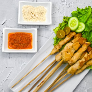 Sate Taichan, kızarmış tavuk, fıstık sosu ve soya sosu olmadan. Tabakta sambal (acı sos) ile servis edilir. Seçili odak.