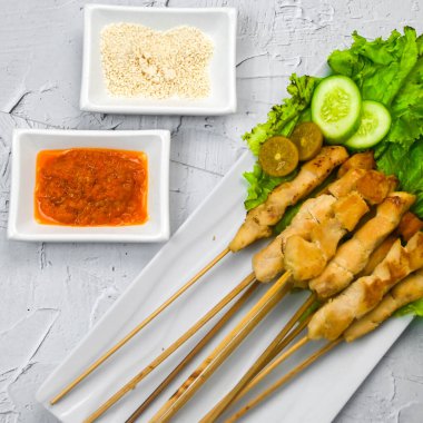 Sate Taichan, kızarmış tavuk, fıstık sosu ve soya sosu olmadan. Tabakta sambal (acı sos) ile servis edilir. Seçili odak.