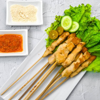 Sate Taichan, kızarmış tavuk, fıstık sosu ve soya sosu olmadan. Tabakta sambal (acı sos) ile servis edilir. Seçili odak.