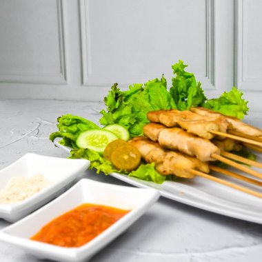 Sate Taichan, kızarmış tavuk, fıstık sosu ve soya sosu olmadan. Tabakta sambal (acı sos) ile servis edilir. Seçili odak.