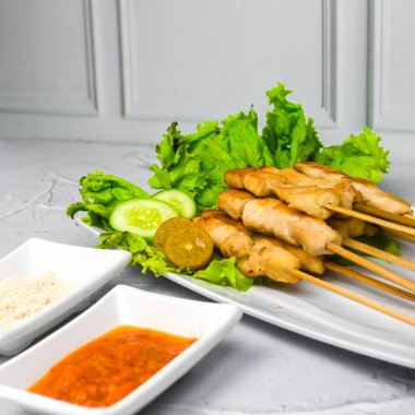 Sate Taichan, kızarmış tavuk, fıstık sosu ve soya sosu olmadan. Tabakta sambal (acı sos) ile servis edilir. Seçili odak.