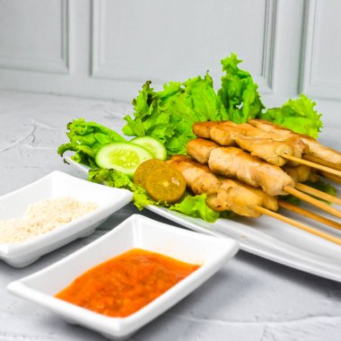 Sate Taichan, kızarmış tavuk, fıstık sosu ve soya sosu olmadan. Tabakta sambal (acı sos) ile servis edilir. Seçili odak.