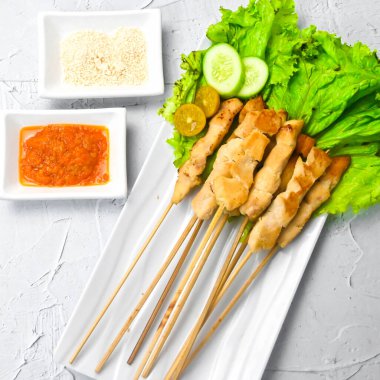 Sate Taichan, kızarmış tavuk, fıstık sosu ve soya sosu olmadan. Tabakta sambal (acı sos) ile servis edilir. Seçili odak.