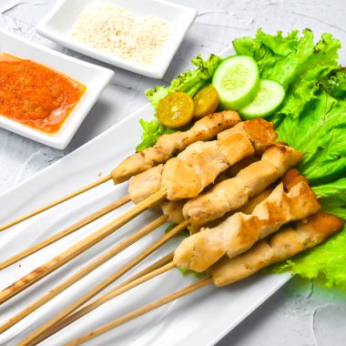 Sate Taichan, kızarmış tavuk, fıstık sosu ve soya sosu olmadan. Tabakta sambal (acı sos) ile servis edilir. Seçili odak.