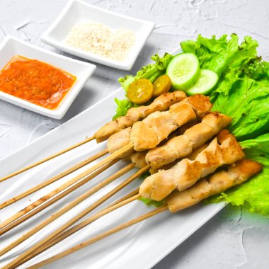 Sate Taichan, kızarmış tavuk, fıstık sosu ve soya sosu olmadan. Tabakta sambal (acı sos) ile servis edilir. Seçili odak.