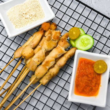 Sate Taichan, kızarmış tavuk, fıstık sosu ve soya sosu olmadan. Tabakta sambal (acı sos) ile servis edilir. Seçili odak.