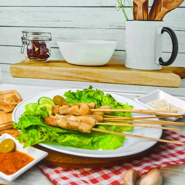 Sate Taichan, Grilled Chicken Satay without peanut sauce or soy sauce. Served on plate with sambal (chilli sauce). Selected focus.