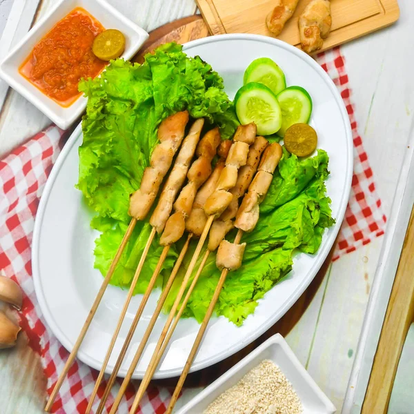 Sate Taichan, Grilled Chicken Satay without peanut sauce or soy sauce. Served on plate with sambal (chilli sauce). Selected focus.