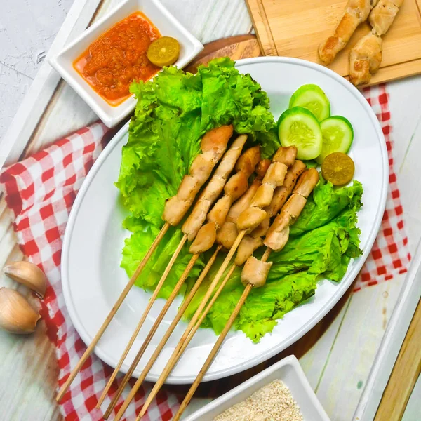 Sate Taichan, Grilled Chicken Satay without peanut sauce or soy sauce. Served on plate with sambal (chilli sauce). Selected focus.