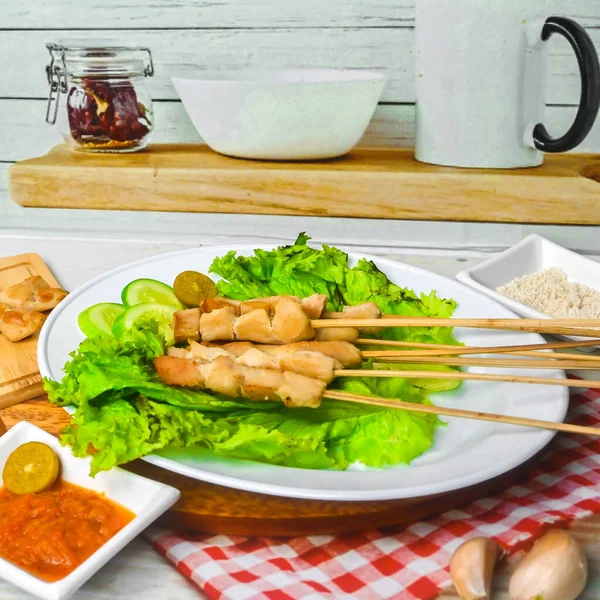 Sate Taichan, Grilled Chicken Satay without peanut sauce or soy sauce. Served on plate with sambal (chilli sauce). Selected focus.