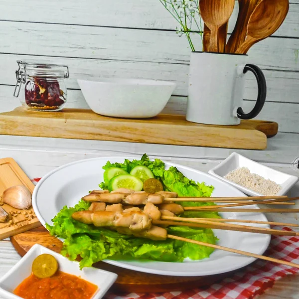 Sate Taichan, Grilled Chicken Satay without peanut sauce or soy sauce. Served on plate with sambal (chilli sauce). Selected focus.