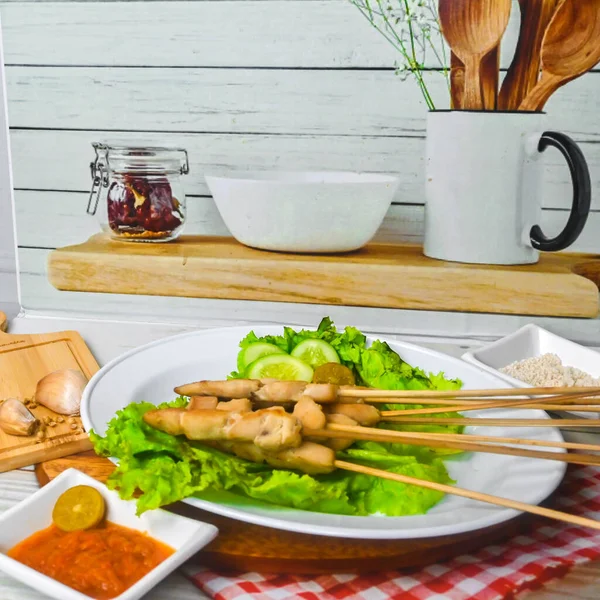 Sate Taichan, Grilled Chicken Satay without peanut sauce or soy sauce. Served on plate with sambal (chilli sauce). Selected focus.