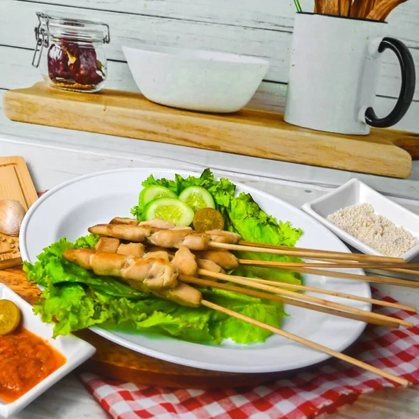 Sate Taichan, Grilled Chicken Satay without peanut sauce or soy sauce. Served on plate with sambal (chilli sauce). Selected focus.