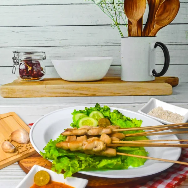 Sate Taichan, Grilled Chicken Satay without peanut sauce or soy sauce. Served on plate with sambal (chilli sauce). Selected focus.