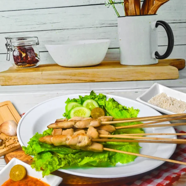 Sate Taichan, Grilled Chicken Satay without peanut sauce or soy sauce. Served on plate with sambal (chilli sauce). Selected focus.