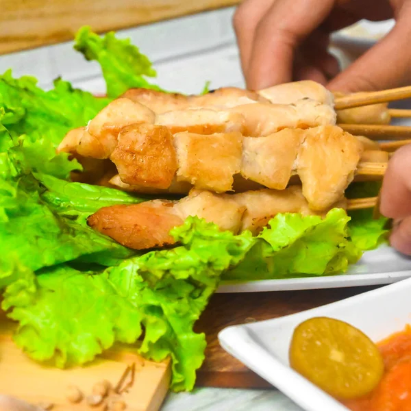 Sate Taichan, Grilled Chicken Satay without peanut sauce or soy sauce. Served on plate with sambal (chilli sauce). Selected focus.