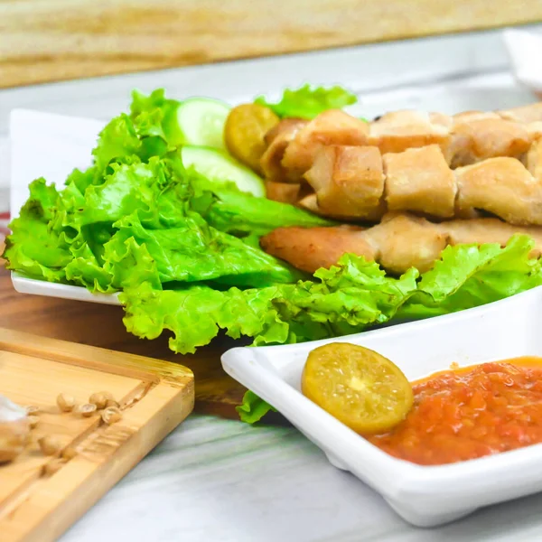 Sate Taichan, Grilled Chicken Satay without peanut sauce or soy sauce. Served on plate with sambal (chilli sauce). Selected focus.