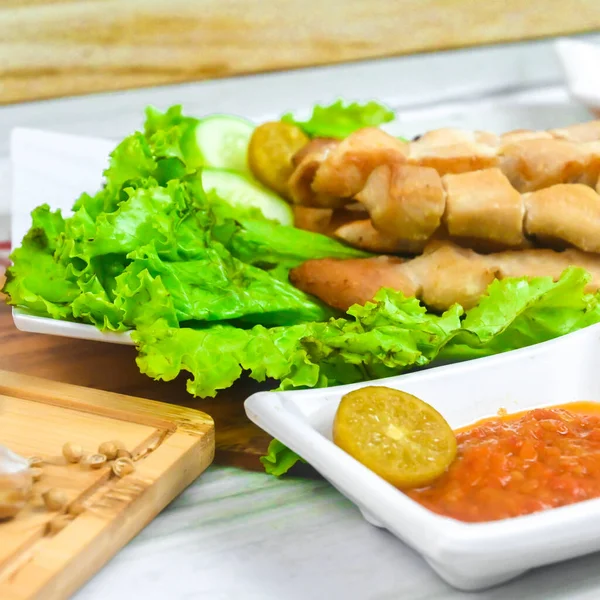 Sate Taichan, Grilled Chicken Satay without peanut sauce or soy sauce. Served on plate with sambal (chilli sauce). Selected focus.