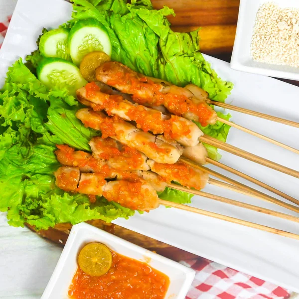 Sate Taichan, Grilled Chicken Satay without peanut sauce or soy sauce. Served on plate with sambal (chilli sauce). Selected focus.