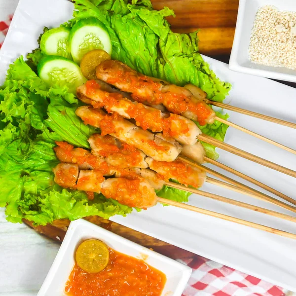Sate Taichan, Grilled Chicken Satay without peanut sauce or soy sauce. Served on plate with sambal (chilli sauce). Selected focus.
