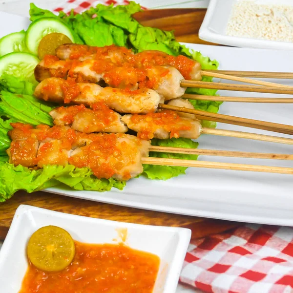 Sate Taichan, Grilled Chicken Satay without peanut sauce or soy sauce. Served on plate with sambal (chilli sauce). Selected focus.