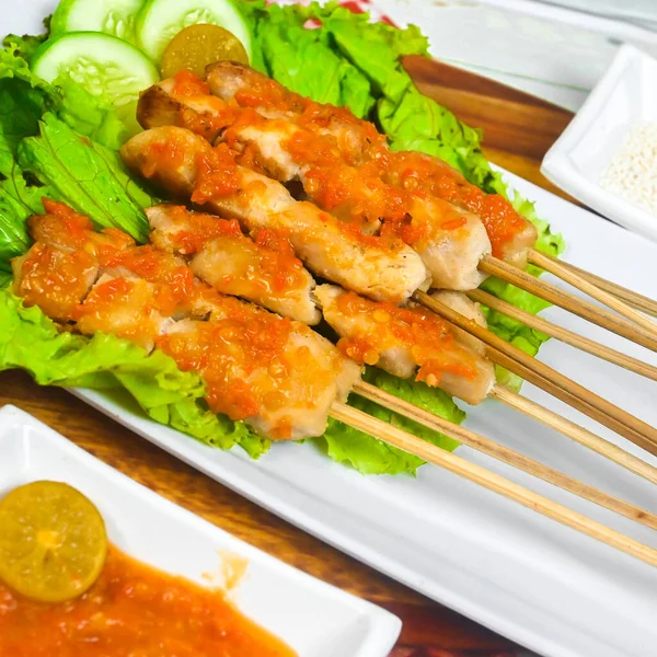 Sate Taichan, Grilled Chicken Satay without peanut sauce or soy sauce. Served on plate with sambal (chilli sauce). Selected focus.