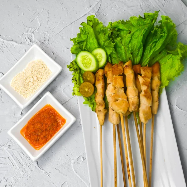 Sate Taichan, Grilled Chicken Satay without peanut sauce or soy sauce. Served on plate with sambal (chilli sauce). Selected focus.