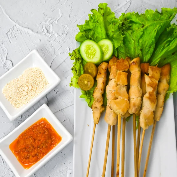 Sate Taichan, Grilled Chicken Satay without peanut sauce or soy sauce. Served on plate with sambal (chilli sauce). Selected focus.