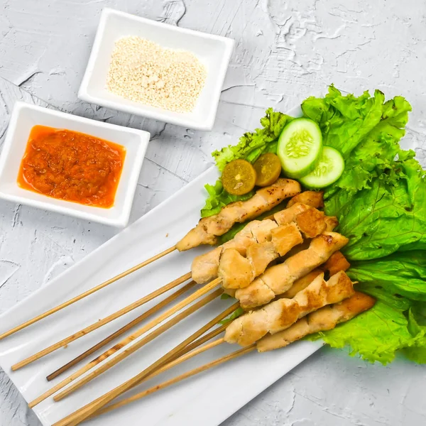 Sate Taichan, Grilled Chicken Satay without peanut sauce or soy sauce. Served on plate with sambal (chilli sauce). Selected focus.