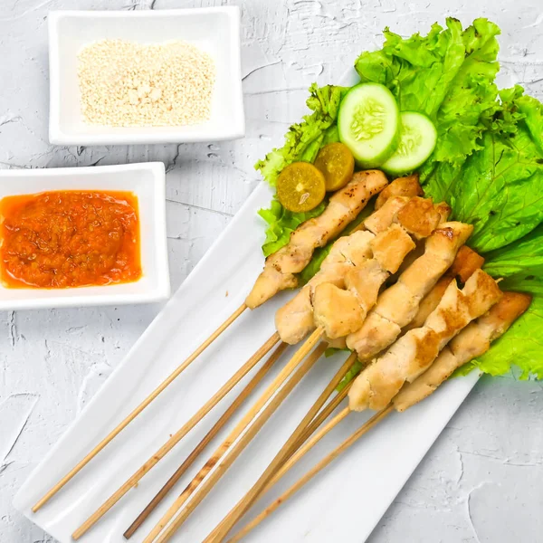 Sate Taichan, Grilled Chicken Satay without peanut sauce or soy sauce. Served on plate with sambal (chilli sauce). Selected focus.