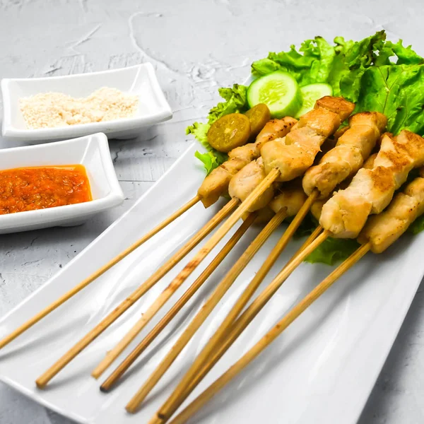 Sate Taichan, Grilled Chicken Satay without peanut sauce or soy sauce. Served on plate with sambal (chilli sauce). Selected focus.