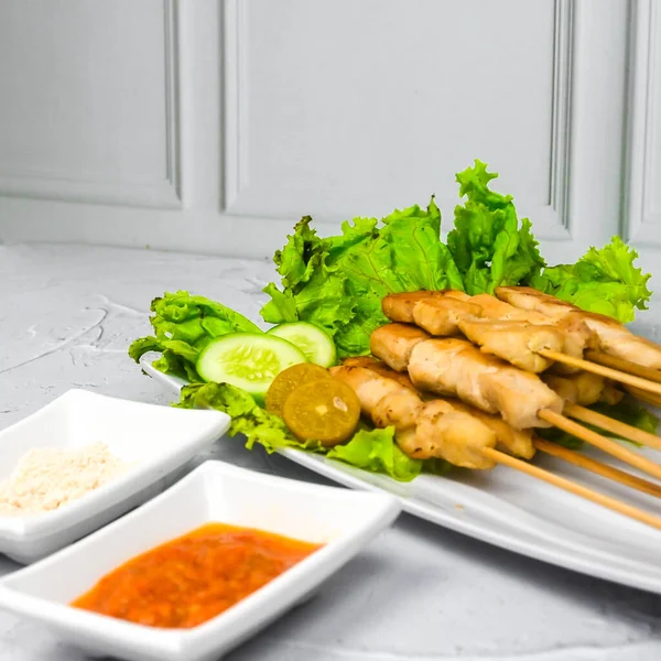 Sate Taichan, Grilled Chicken Satay without peanut sauce or soy sauce. Served on plate with sambal (chilli sauce). Selected focus.