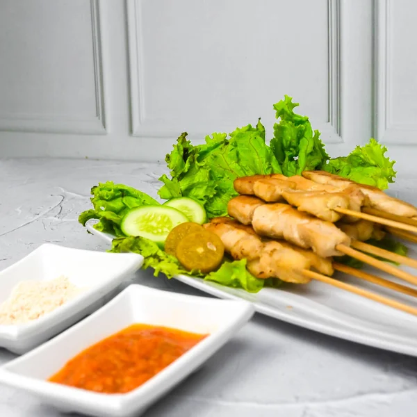 Sate Taichan, Grilled Chicken Satay without peanut sauce or soy sauce. Served on plate with sambal (chilli sauce). Selected focus.