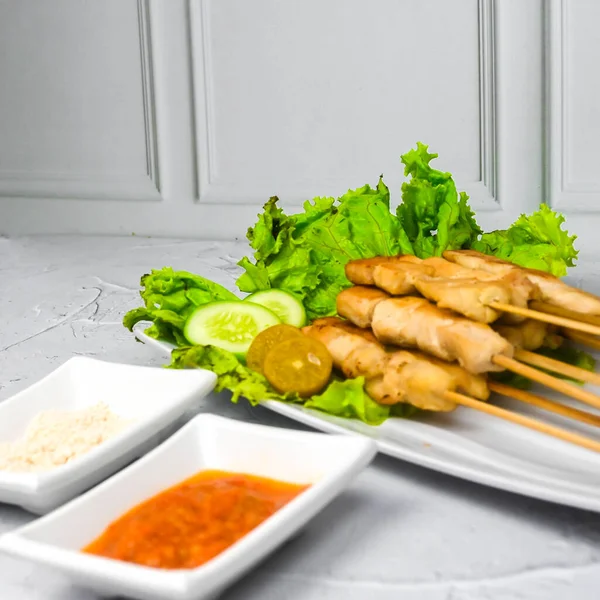 Sate Taichan, Grilled Chicken Satay without peanut sauce or soy sauce. Served on plate with sambal (chilli sauce). Selected focus.