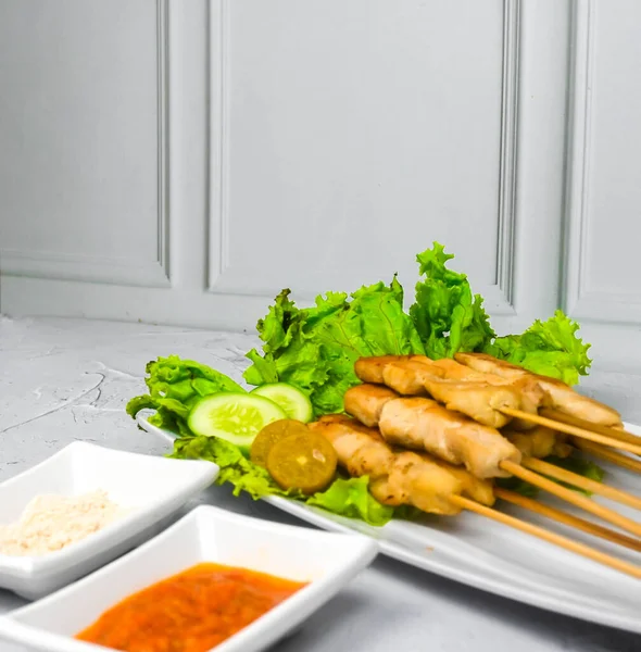 Sate Taichan, Grilled Chicken Satay without peanut sauce or soy sauce. Served on plate with sambal (chilli sauce). Selected focus.