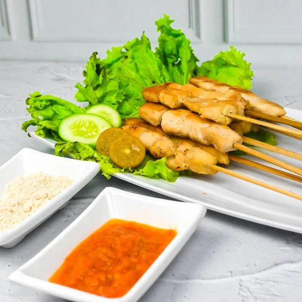 Sate Taichan, Grilled Chicken Satay without peanut sauce or soy sauce. Served on plate with sambal (chilli sauce). Selected focus.