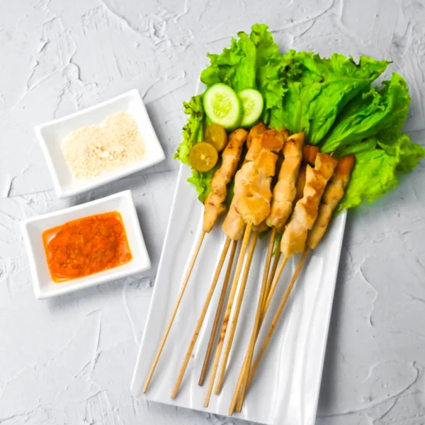 Sate Taichan, Grilled Chicken Satay without peanut sauce or soy sauce. Served on plate with sambal (chilli sauce). Selected focus.