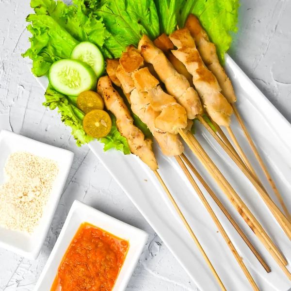 Sate Taichan, Grilled Chicken Satay without peanut sauce or soy sauce. Served on plate with sambal (chilli sauce). Selected focus.