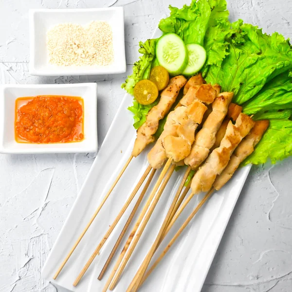 Sate Taichan, Grilled Chicken Satay without peanut sauce or soy sauce. Served on plate with sambal (chilli sauce). Selected focus.