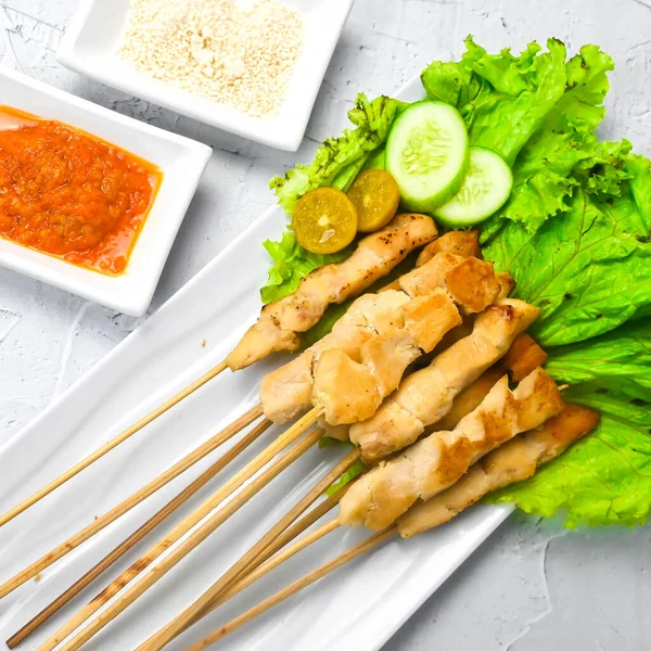 Sate Taichan, Grilled Chicken Satay without peanut sauce or soy sauce. Served on plate with sambal (chilli sauce). Selected focus.