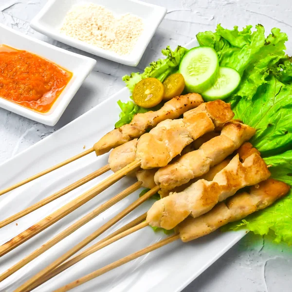 Sate Taichan, Grilled Chicken Satay without peanut sauce or soy sauce. Served on plate with sambal (chilli sauce). Selected focus.