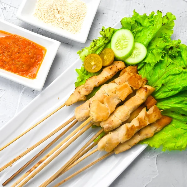 Sate Taichan, Grilled Chicken Satay without peanut sauce or soy sauce. Served on plate with sambal (chilli sauce). Selected focus.