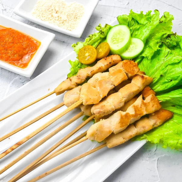 Sate Taichan, Grilled Chicken Satay without peanut sauce or soy sauce. Served on plate with sambal (chilli sauce). Selected focus.