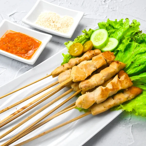Sate Taichan, Grilled Chicken Satay without peanut sauce or soy sauce. Served on plate with sambal (chilli sauce). Selected focus.