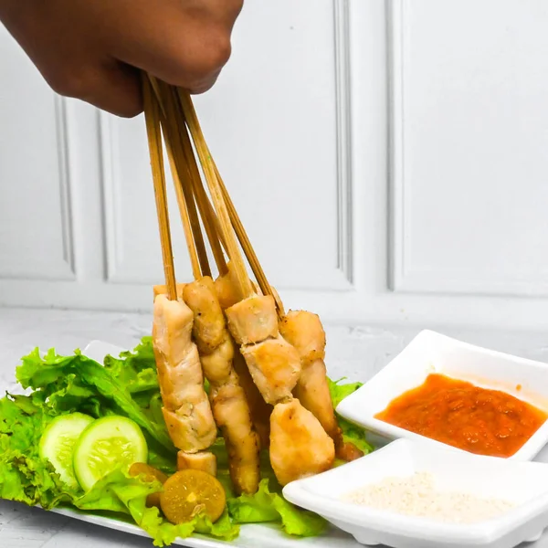 Sate Taichan, Grilled Chicken Satay without peanut sauce or soy sauce. Served on plate with sambal (chilli sauce). Selected focus.