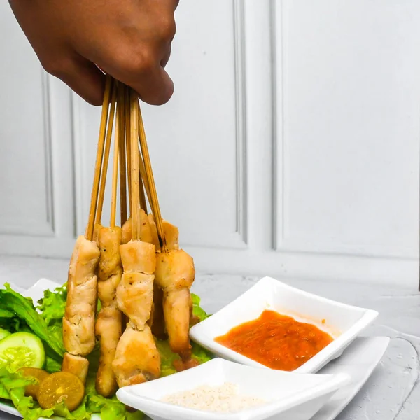 Sate Taichan, Grilled Chicken Satay without peanut sauce or soy sauce. Served on plate with sambal (chilli sauce). Selected focus.