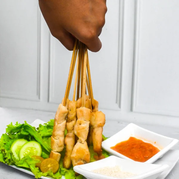 Sate Taichan, Grilled Chicken Satay without peanut sauce or soy sauce. Served on plate with sambal (chilli sauce). Selected focus.