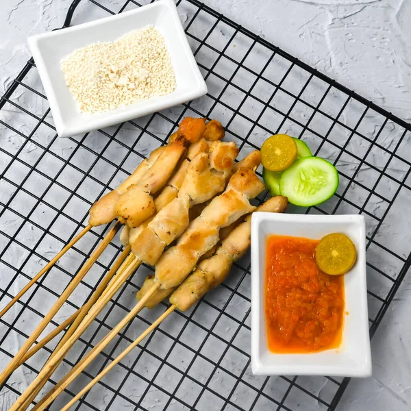 Sate Taichan, Grilled Chicken Satay without peanut sauce or soy sauce. Served on plate with sambal (chilli sauce). Selected focus.